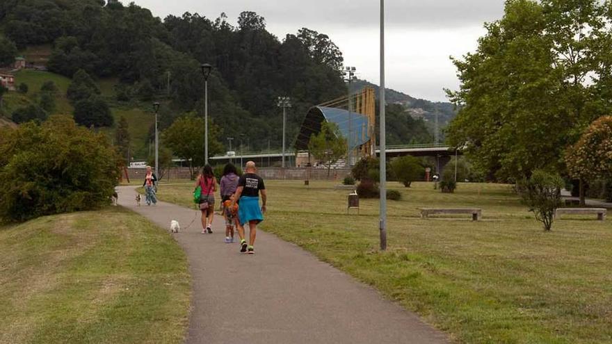 Varias personas, por la senda del Parque Inglés de El Entrego, que se pide que pase a llamarse Parque de las Víctimas del Terrorismo.