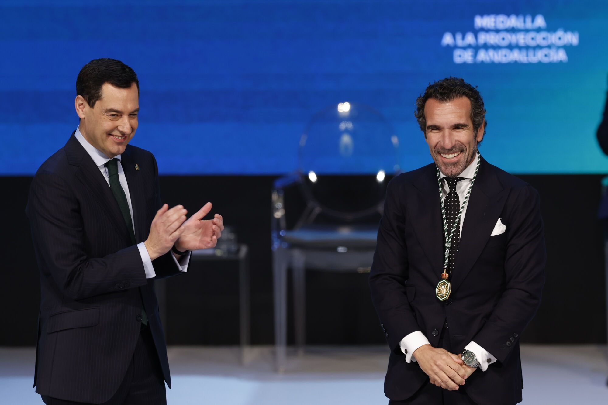 GRAFAND6603. SEVILLA, 28/02/2025.- El presidente de la Junta de Andalucía, Juanma Moreno (i), tras imponer la Medalla a la Proyección de Andalucía a Borja Vázquez que recoge en nombre de la empresa Scalpers en la que ha recaído el galardón, durante el acto institucional de entrega de las distinciones de Hijo/a Predilecto/a y las Medallas de Andalucía, este viernes en Sevilla. EFE/Julio Muñoz