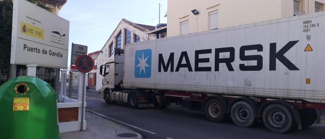 Un gran camión entra, ayer, al puerto de Gandia tras circular por la calle de Llevant, que cruza el Grau.