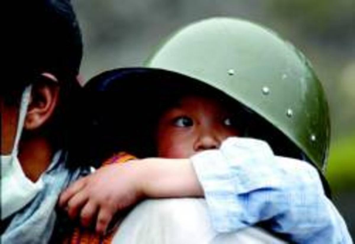 Una nena amb un casc militar surt de Yingxiu durant l’evacuació massiva després del terratrèmol.