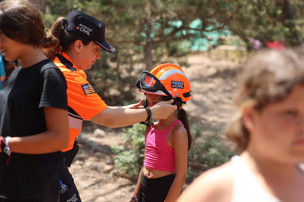 Una niña se prueba el casco de Protección Civil.