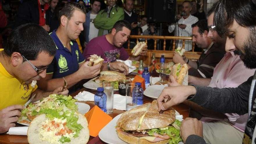 Seis de los 21 participantes en el reto del Florida, ayer, comiendo su maxihamburguesa.//Bernabé / Javier Lalín