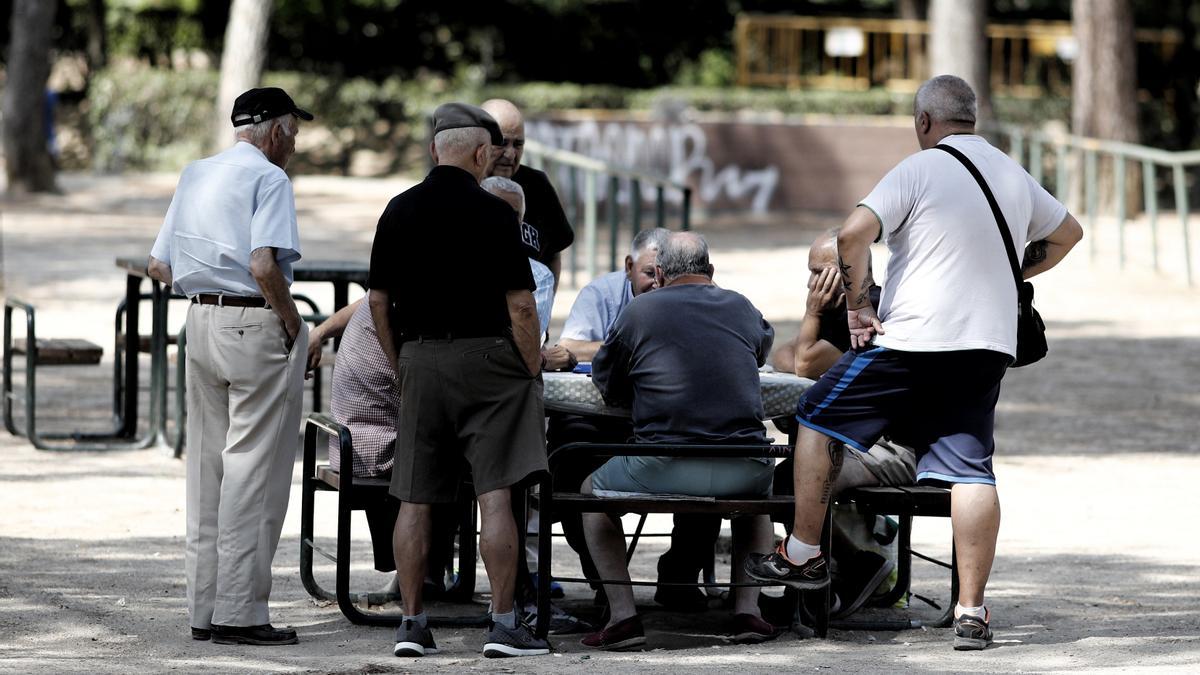 Archivo - Varios pensionistas juegan al dominó en un parque de Madrid