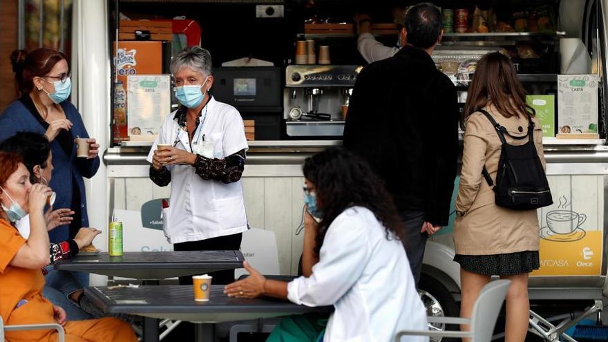 Varias personas toman un descanso frente al servicio de urgencias del Hospital de Bellvitge.