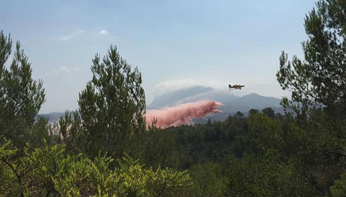Un avió llança aigua sobre l’incendi d’Òdena, aquest dilluns.