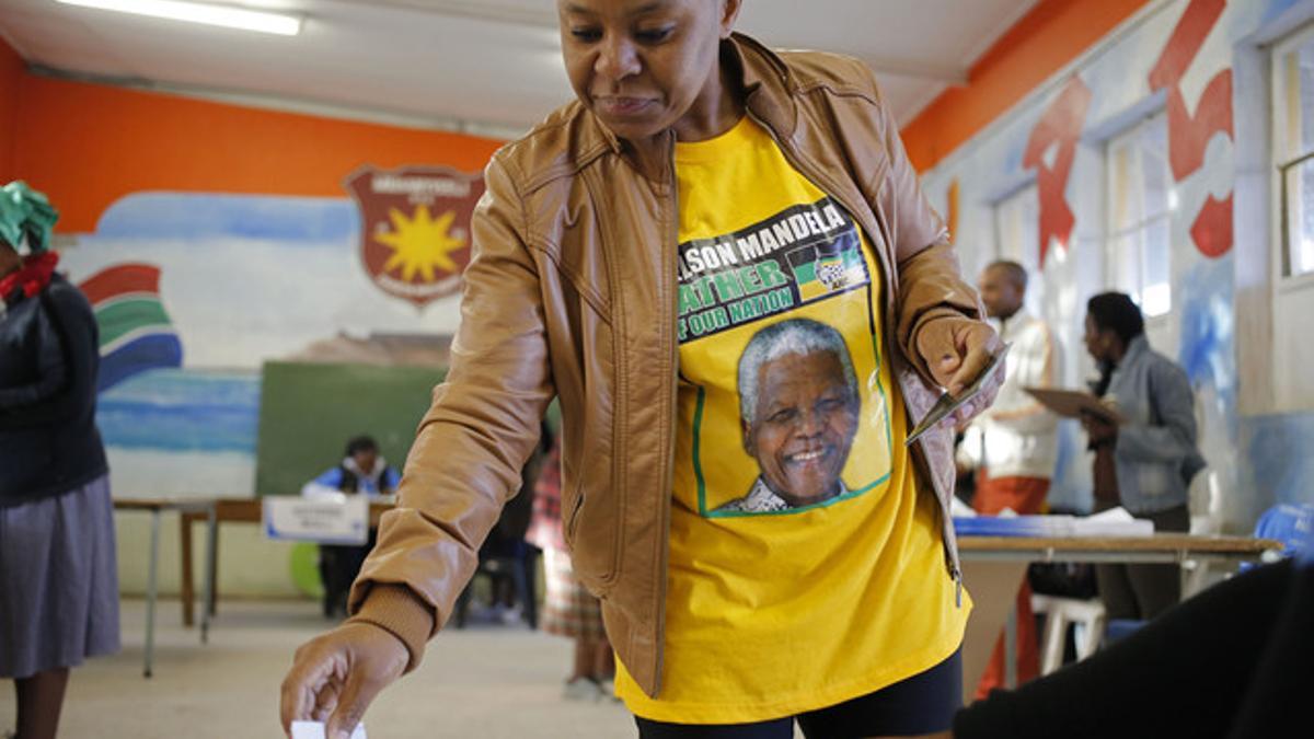 Una mujer con una camiseta con la imagen de Nelson Mandela ejerce su derecho a voto, este miércoles en la localidad de Nyanga, en las afueras de Ciudad del Cabo.