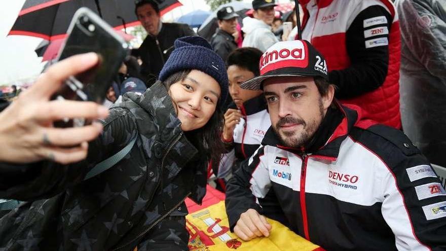 Alonso se fotografía con una aficionada antes de la carrera de Shanghái. // James Muy