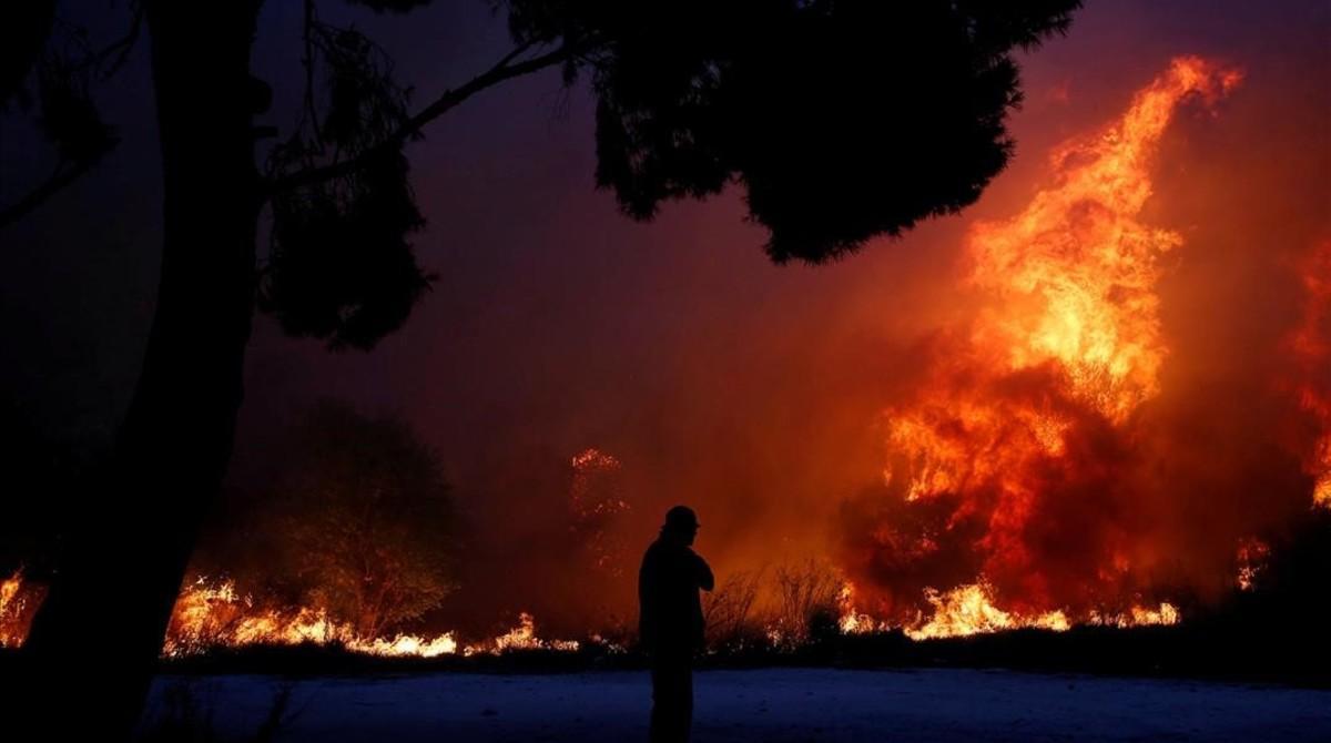 undefined44427136 a man looks at the flames as a wildfire burns in the town of180724142409