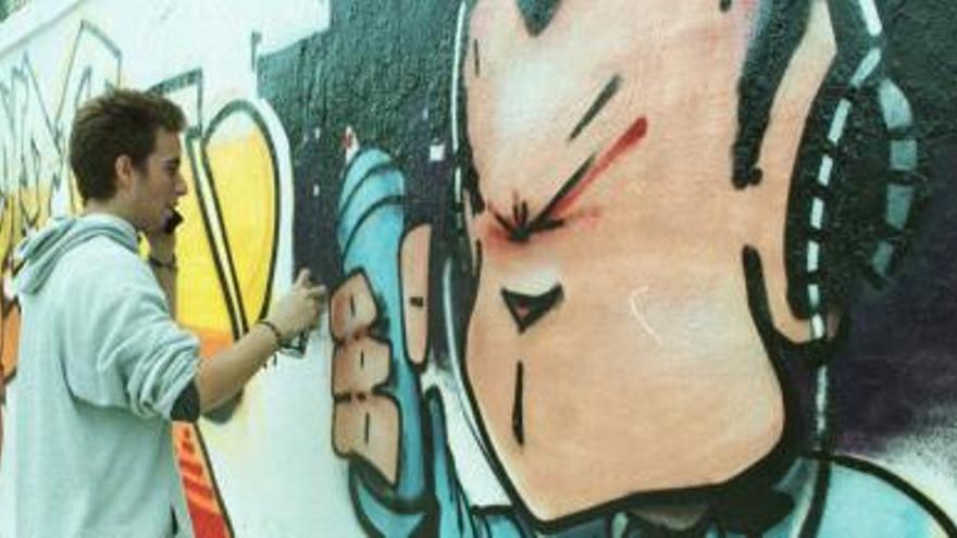 Un graffitero hace un dibujo en una de las paredes del centro de recursos juveniles de Cartagena
