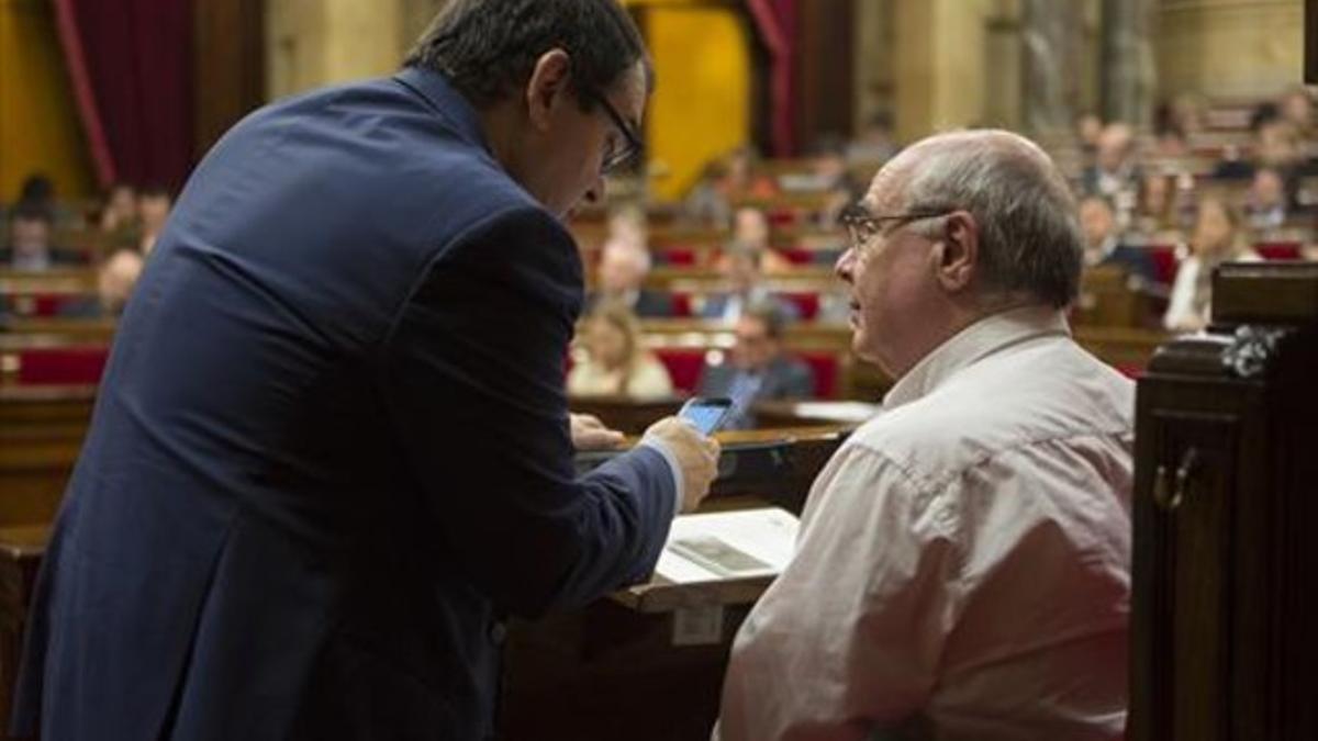 Lluís Rabell (derecha) conversa con Jordi Jané, en el Parlament.