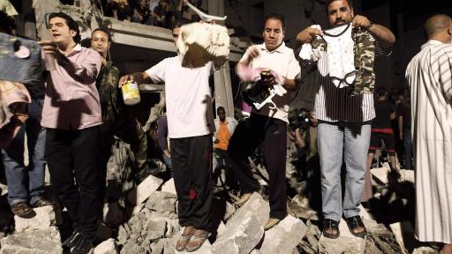 Ciudadanos libios muestran ropas de niños tras el bombardeo de la OTAN.