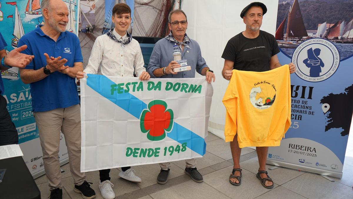 Luis Pérez e Teo Alberro, 2º e 3º pola esqda., coa bandeira da Festa da Dorna de Ribeira, na presentación do encontro Culturmar
