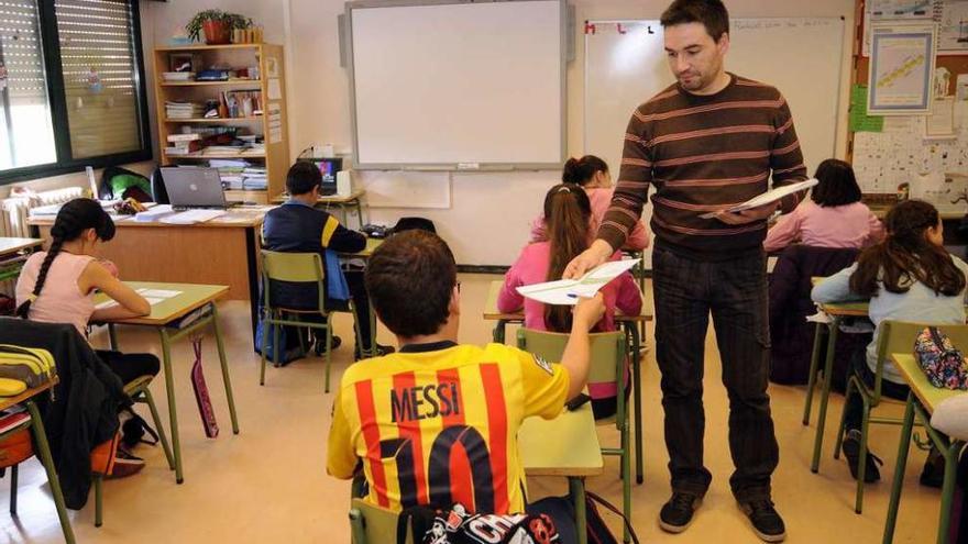 Un profesor reparte las pruebas entre el alumnado de sexto del colegio de Rodeiro. // Bernabé/Javier Lalín