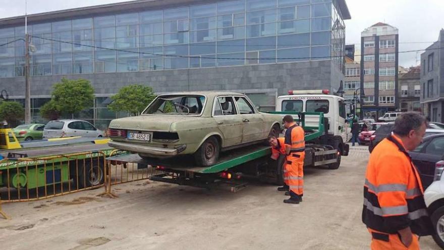 Arriba, varios operarios retiran coches de Ojea. Abajo, el que se quiere destinar a la Policía // G.N.