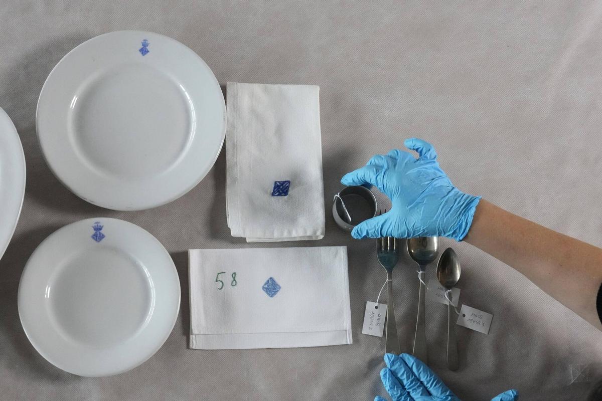 Vajilla, cubiertos y servilletas con el escudo municipal de un comedor escolar de la primera mitad de siglo XX, de la colección de objetos pedagógicos del Museu d'Història de Barcelona