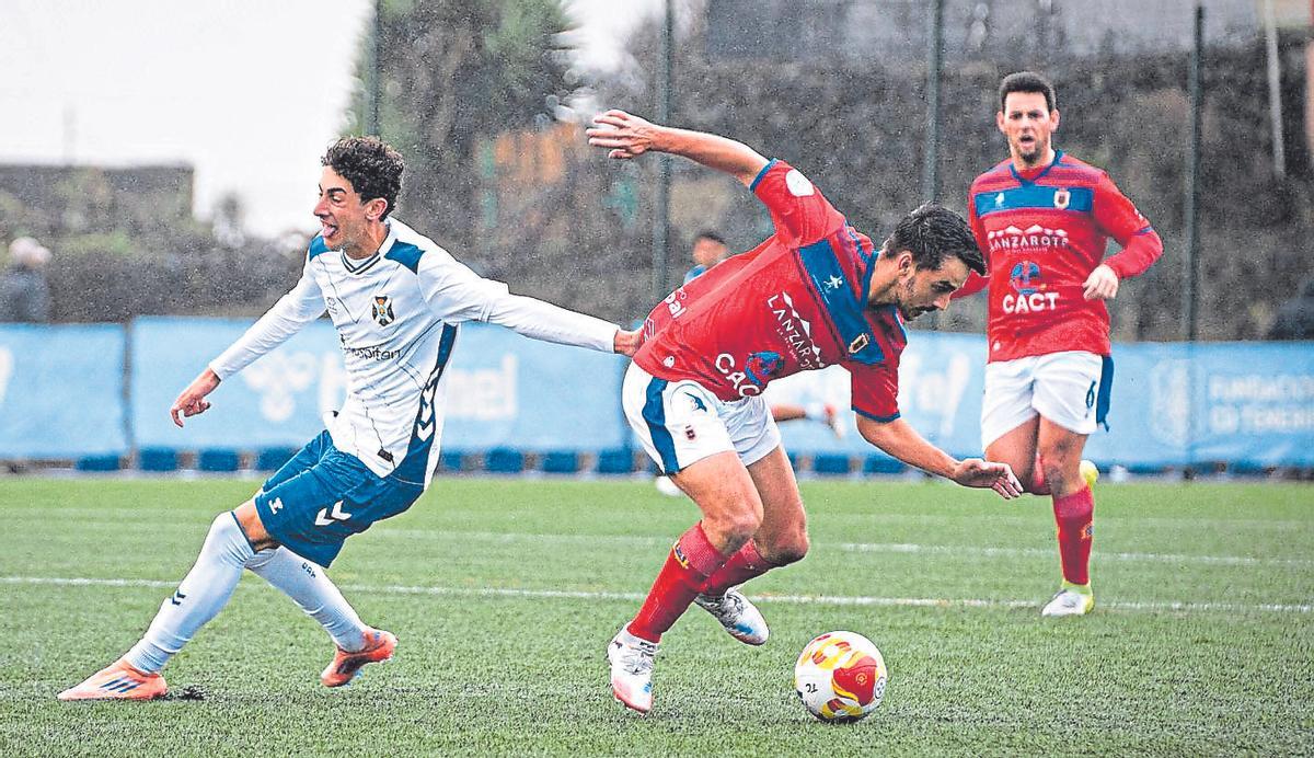 Un jugador del Lanzarote es sujetado por un rival, en un lance del choque de ayer en Tenerife.