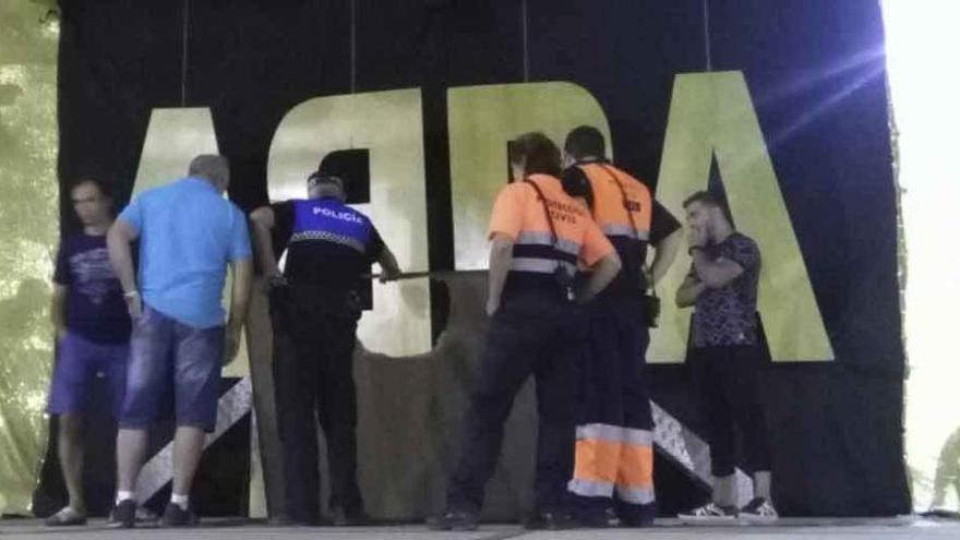 Efectivos de la Policía Local y de Protección Civil revisan el tablero del escenario que cedió.