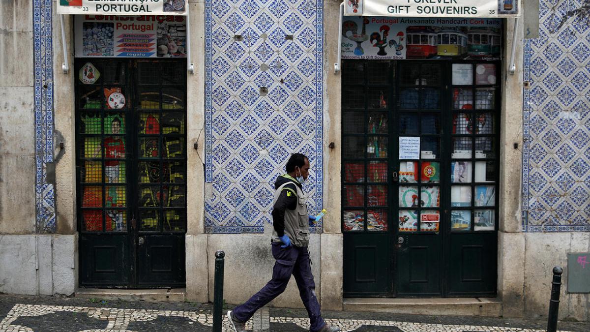 Un hombre camina por las calles vacías de Lisboa