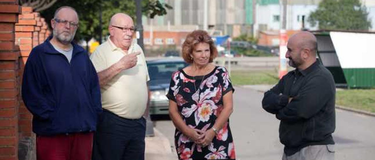 César Fernández, Agustín García, Silvia González y Cruz Heres, en la parroquia de Laviana, con el puerto al fondo.