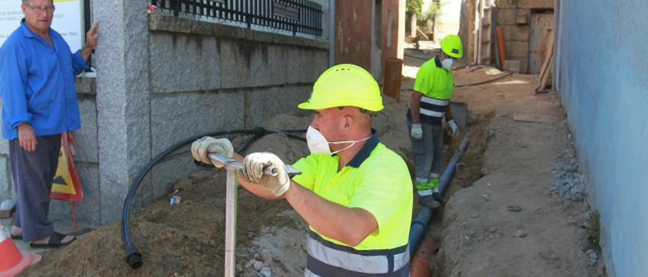 Dos operarios en el núcleo rural de Rairo, en el Concello de Ourense, renovando tuberías.   | // I.O.