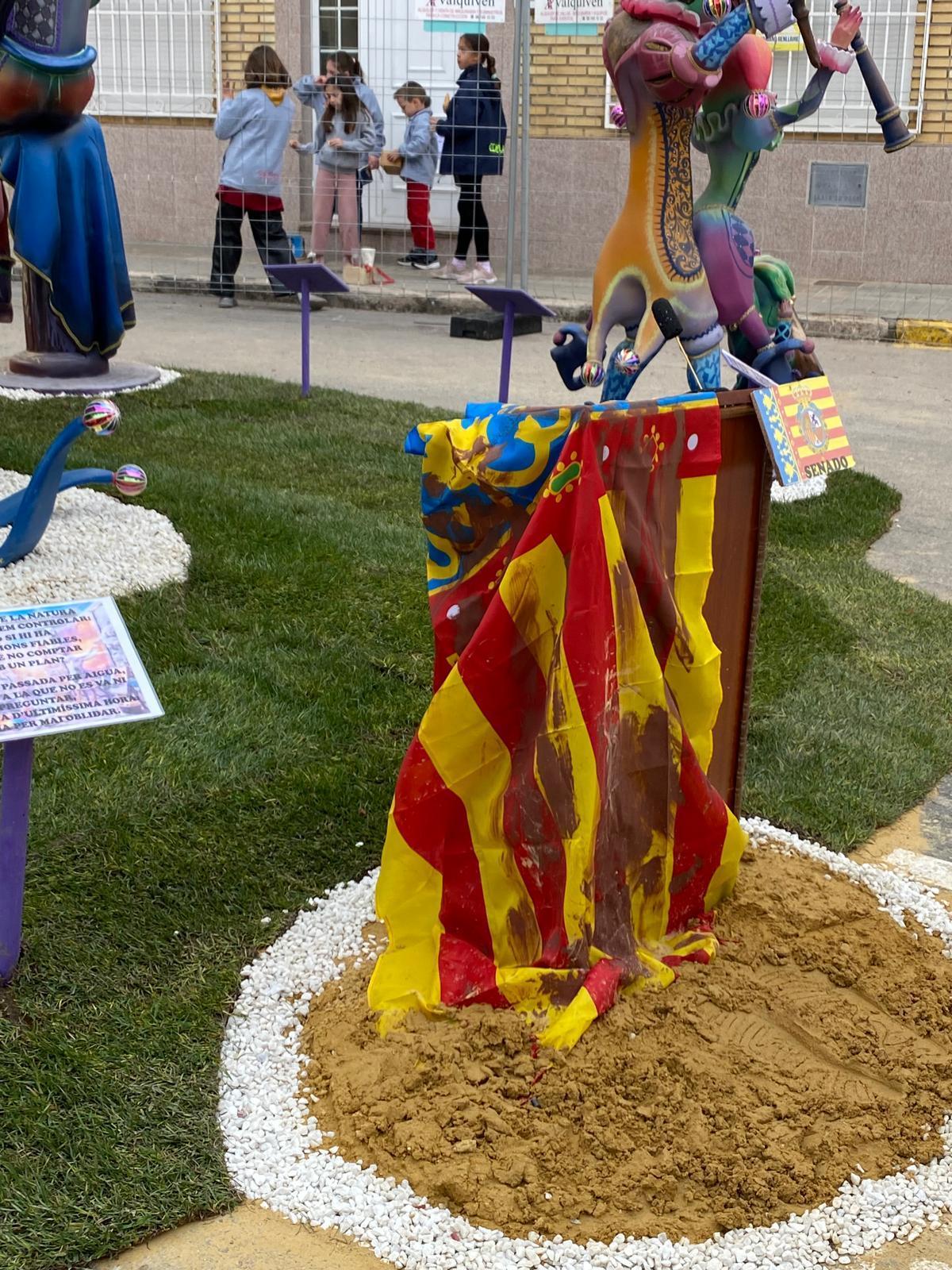 Senyera con barro en la falla de Mariano Benlliure
