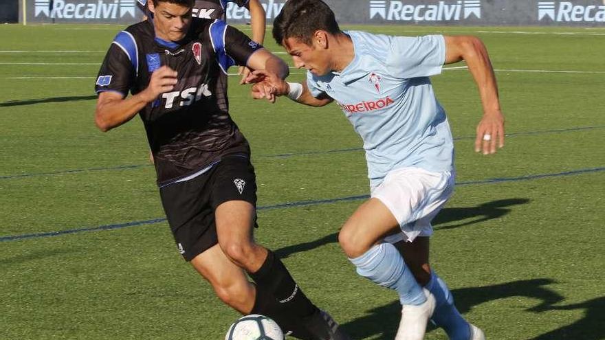 Un jugador del Celta intenta disputar un balón ante la presión de un rival. // Alba Villar