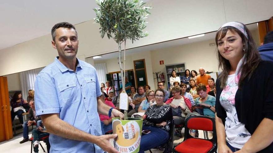 Ángel Díaz recibe el olivo de Paula Nieto, coordinadora de la iniciativa &quot;Oviedo vive sus plazas&quot;.