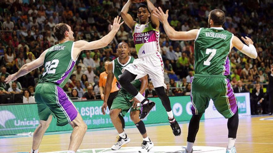 El base estadounidense del Laboral Baskonia, Darius Adams (c), salta para pasar el balón ante los jugadores del Unicaja, el alero griego Kostas Vasieliadis (d), el pívot montenegrino Vladimir Golubovic y el base Jayson Granger (atrás).