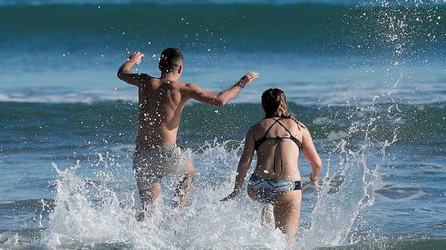 Una pareja se baña en la playa de la Malvarrosa.