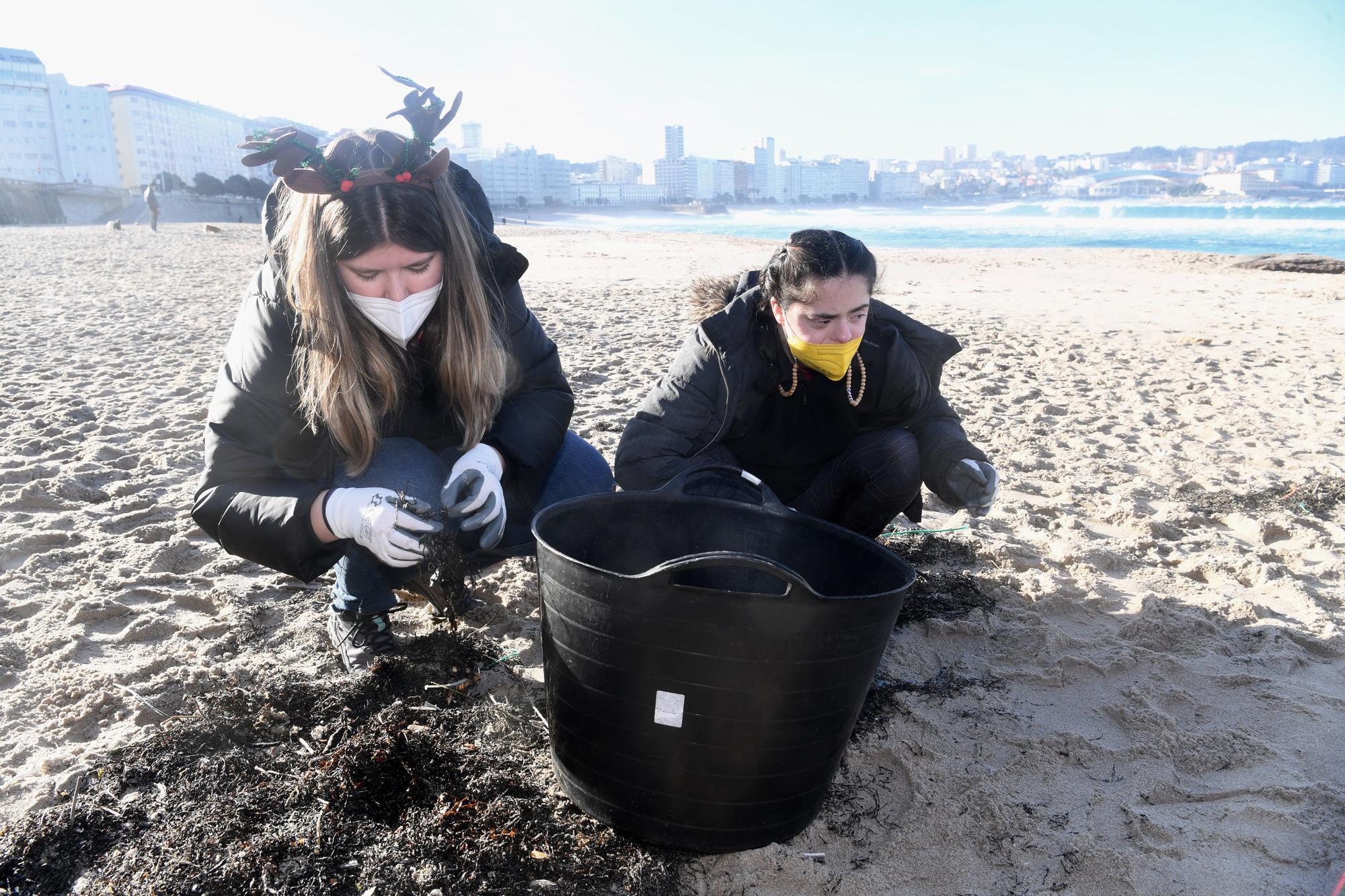 Socios y socias de Down Coruña limpian la playa del Orzán