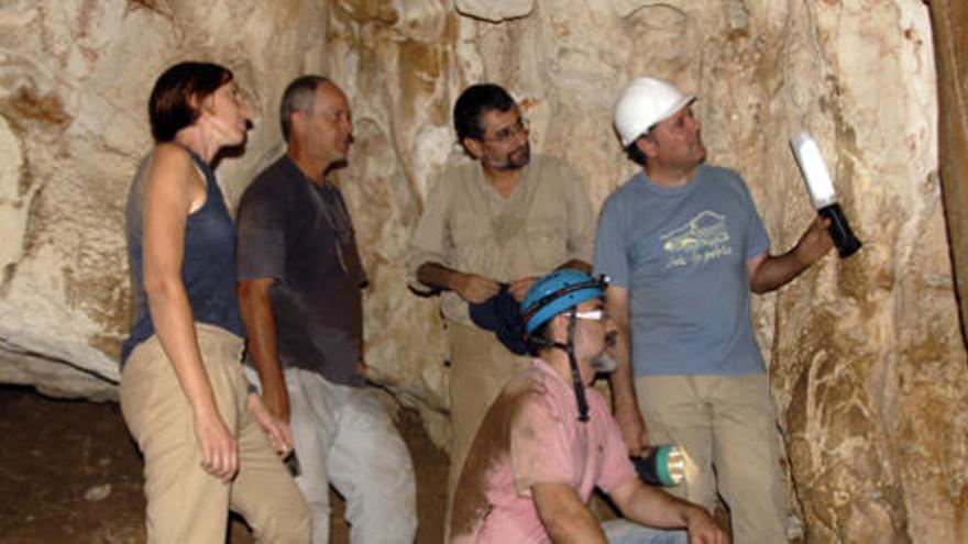 Los arqueólogos observan una de las paredes de la cueva.