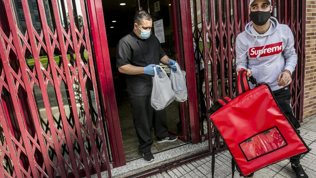 Edgar Manuel Mejías entrega dos bolsas de comida a su repartidor