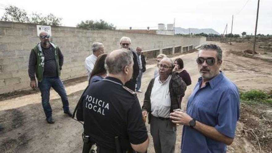 Vecinos de Cañada de Fenollar con agentes de Policía, ayer, junto al muro.