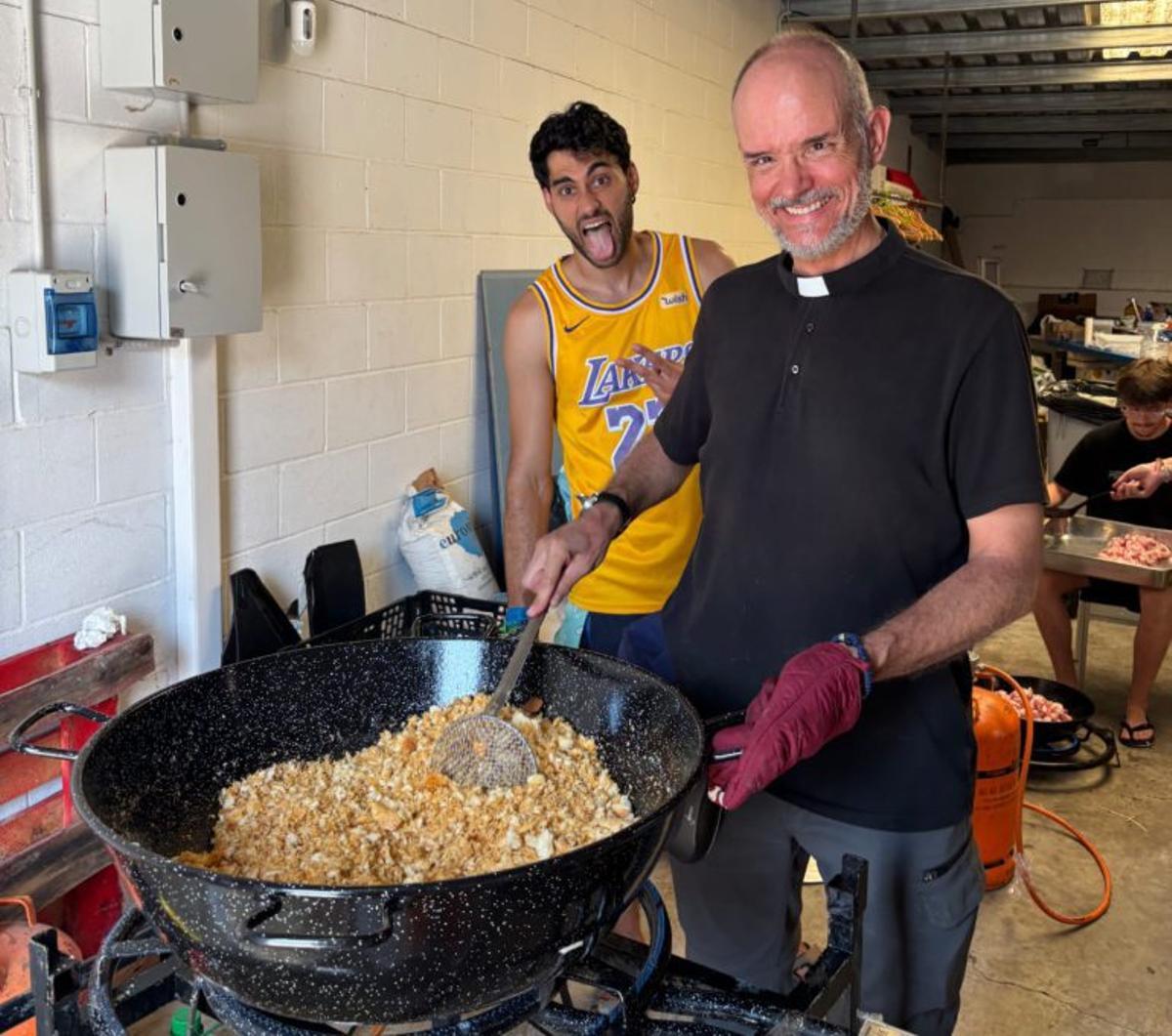 El sacerdote de la parroquia prepara las migas.