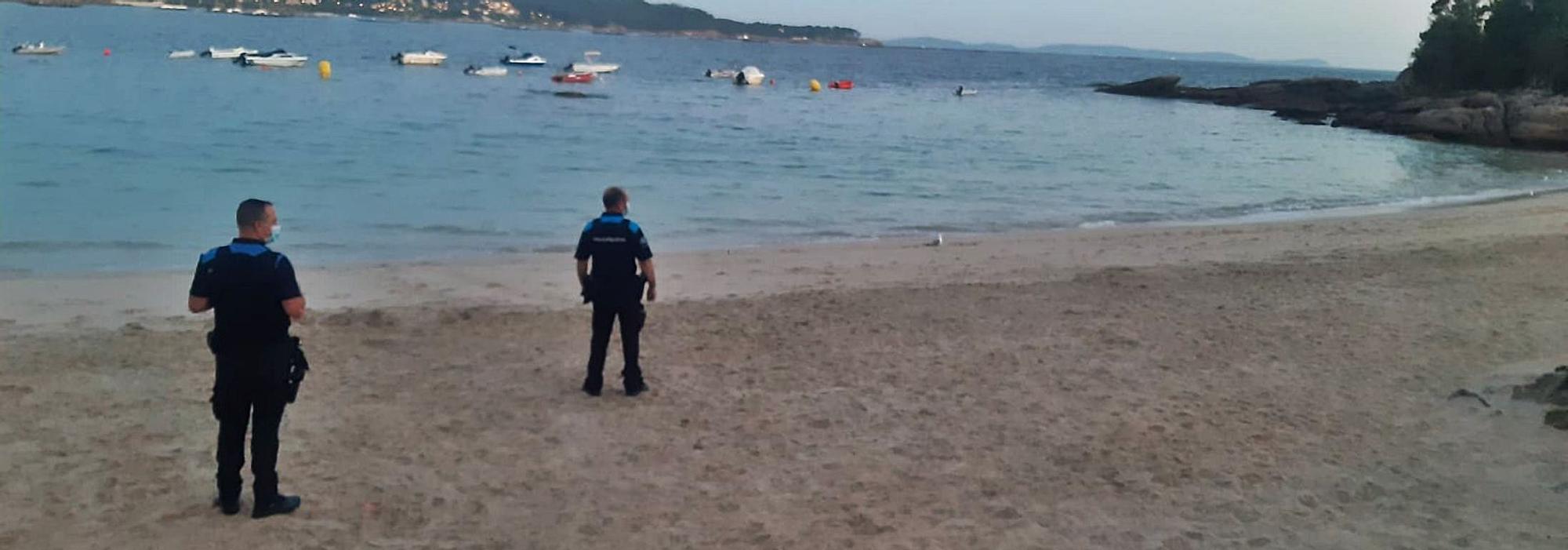 Los agentes de la Policía Local de Cangas en la inspección a primera hora de la mañana de la playa Francón por si había objetos reservando espacio en la arena.