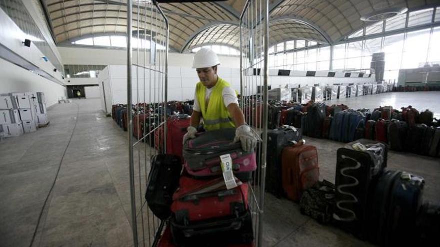 Un operario prueba el nuevo sistema de tratamiento de los equipajes en la futura terminal de El Altet que abrirá en 2011.