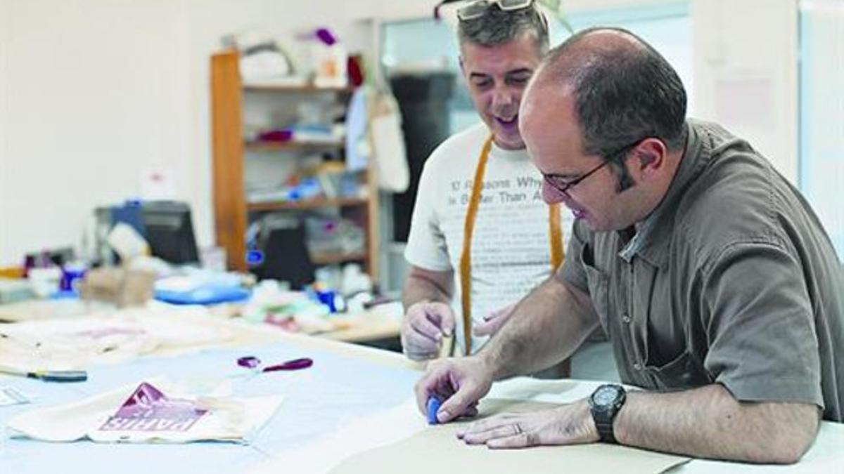 Un educador (a la derecha) enseña a uno de los usuarios del curso prelaboral de la Fundació Estel Tàpies.