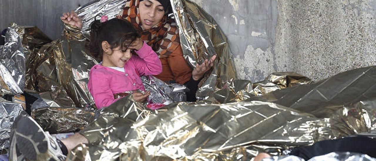 Una mujer y su hija esperan en la frontera entre Hungría y Austria, donde son atendidas antes de poder continuar su viaje hacia Alemania.