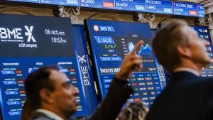 Archivo - Varias personas observan los paneles del Ibex 35 en el Palacio de la Bolsa, a 6 de octubre de 2023, en Madrid (España).