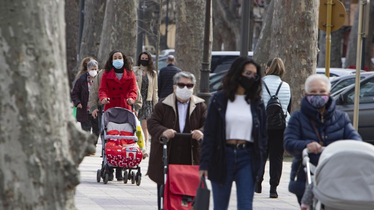 Vecinas de Xàtiva pasean por la calle protegidas con mascarillas.