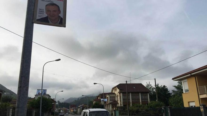 Una farola de la calle Argüelles de Arriondas, con un cartel electoral del PSOE.