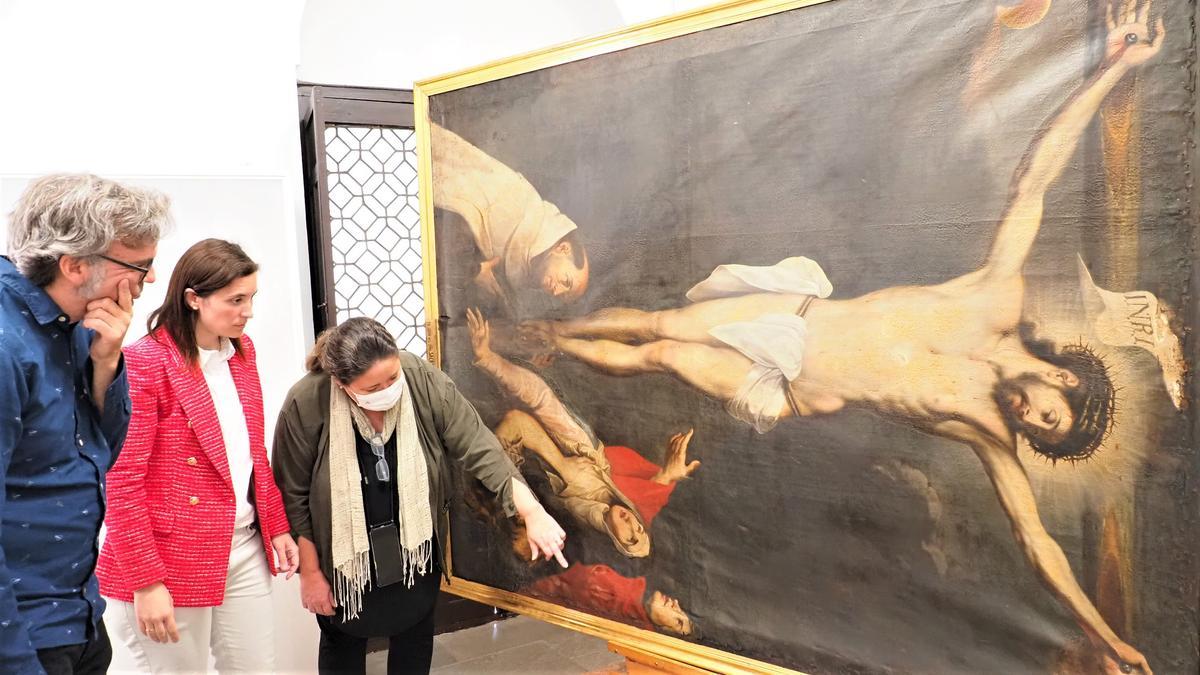 Cristina Casanueva atiende a las explicaciones sobre la restauración del lienzo.