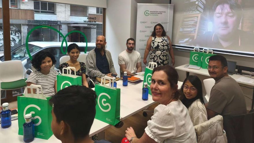Marta García, trabajadora de AECC, al fondo, de pie, con Jordi Arjó, coordinador del campamento, en la pantalla. |