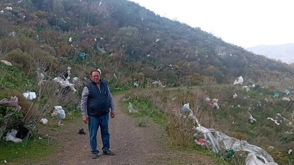 El presidente vecinal de Colmenarejo, José Ángel Moreno, detrás de un cerro cubierto de basura, la semana pasada