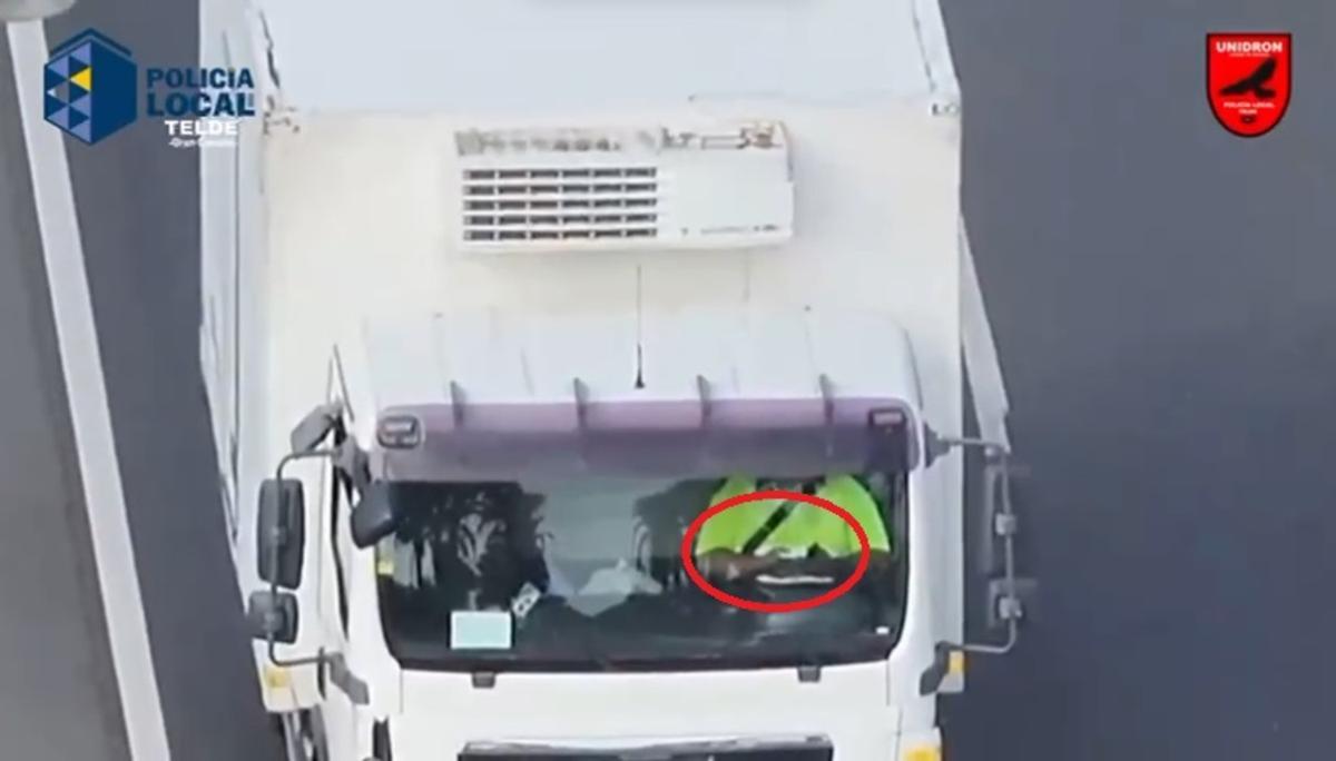 El conductor de un camión frigorífico maneja su teléfono móvil mientras conduce en el municipio de Telde