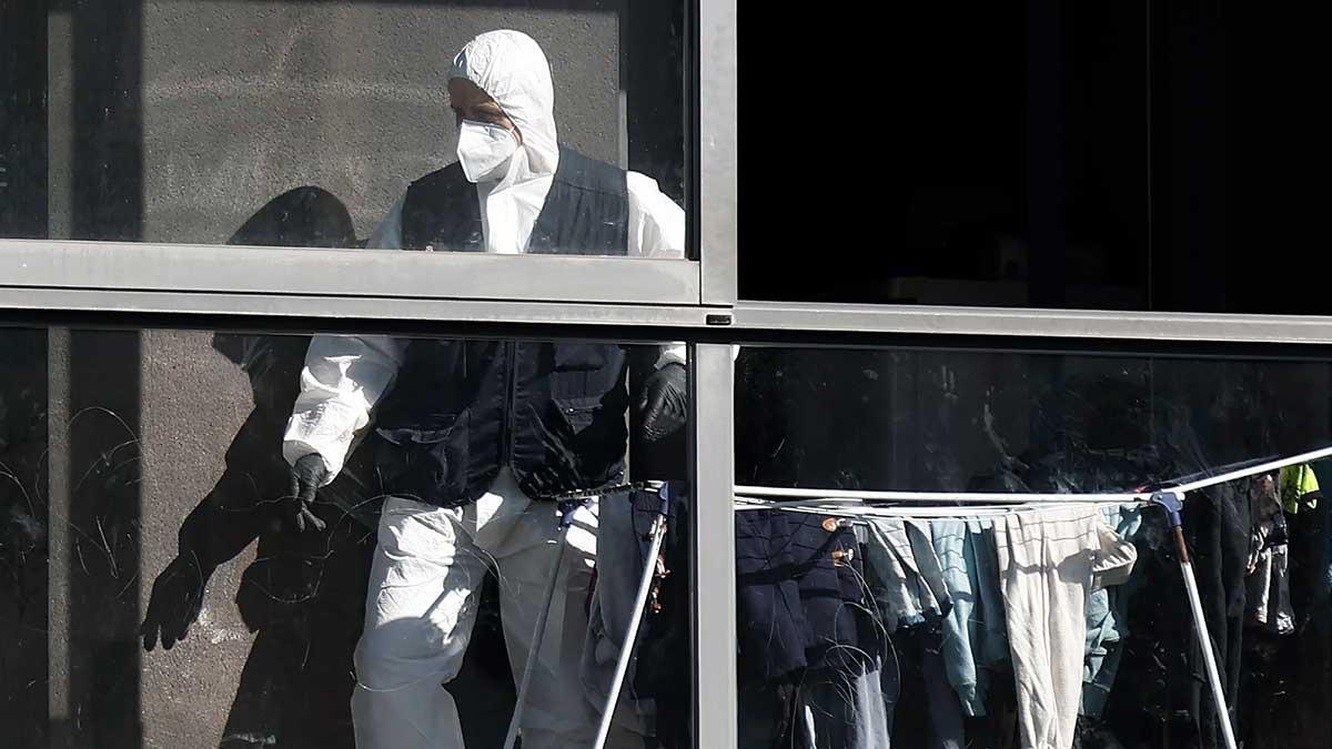 Efectivos de la Policía Judicial de la Policia Foral en el piso donde ayer dos mujeres fueron víctimas, una de ellas asesinada presuntamente por su marido, en un caso de violencia machista y la otra herida de gravedad.