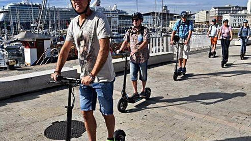 Un grupo de turistas con patinetes eléctricos en A Coruña.
