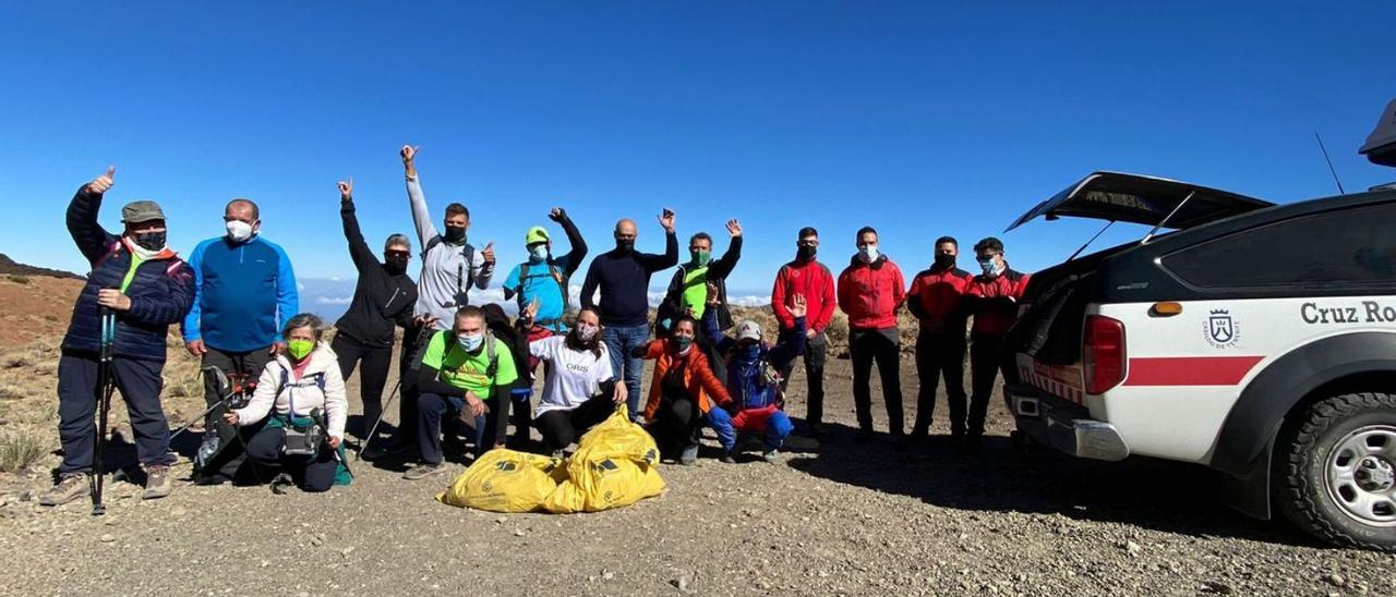 Los voluntarios que participaron en la jornada de limpieza muestran la satisfacción del deber cumplido (arriba). Debajo, dos momentos de la acción llevada a cabo el pasado sábado por senderistas y otros habituales del entorno, con el Refugio de Altavista, que sigue cerrado, de fondo. | e.d.