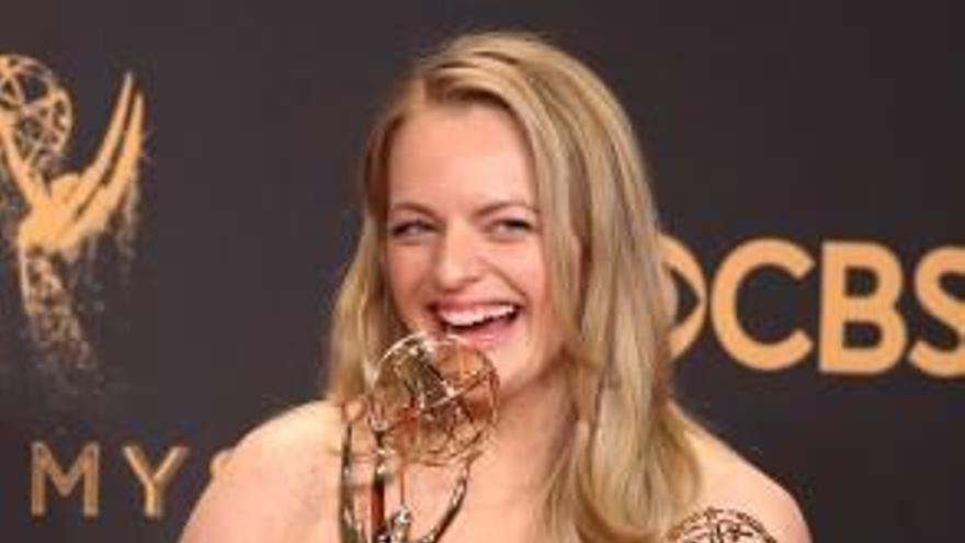 L&#039;actriu Elisabeth Moss posa amb dues estàtues.