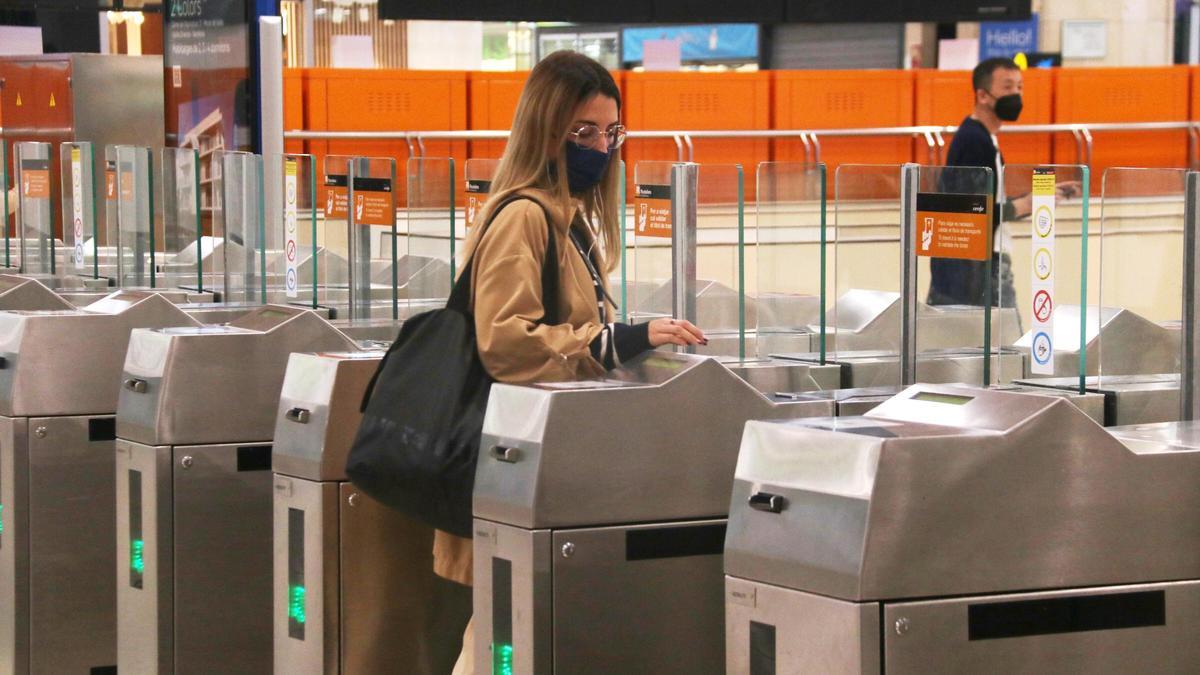 Una usuària de Renfe valida el seu tiquet en una estació de Rodalies